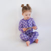 Soft bamboo baby pajamas in purple checkered print, eco-friendly sleepwear.